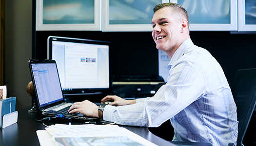 A man seated at his desk and working on his computer